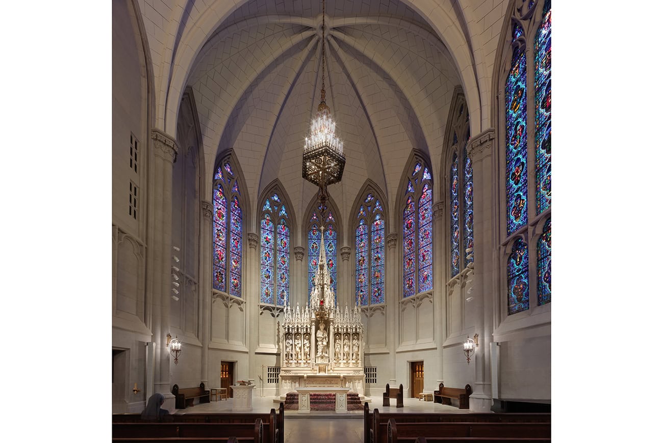 The Caen stone altar framed by stained-glass windows